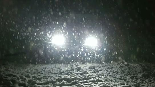 car headlights in a snow storm